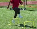 Female athlete stepping over mini hurdles in socks Royalty Free Stock Photo