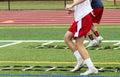 High school football players running ladder drills on the turf