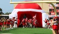 High school football team entering trhe field through a blow up football helmet Royalty Free Stock Photo