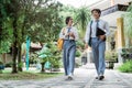 High school girl and boy walk with book and laptop Royalty Free Stock Photo