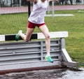 High school girls going over steeplechase barrier into water Royalty Free Stock Photo