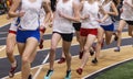 Group of girls running on an indoor track during a track meet Royalty Free Stock Photo