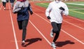 High school girls running in lanes on a red track Royalty Free Stock Photo