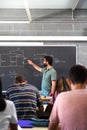 High school male teacher teaching lesson to multiracial teen students. Vertical image. Royalty Free Stock Photo