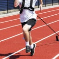 Front view of runner pulling weighted sled on a red track Royalty Free Stock Photo