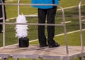 High school marching band conductor stands on metal lift with shako hat with plumes resting near feet Royalty Free Stock Photo