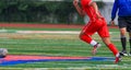 High school soccer player chasing the ball during a game Royalty Free Stock Photo