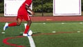 Soccer player in red uniform dribbling the ball downfield Royalty Free Stock Photo