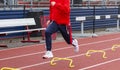 High school sprinter running over six inch mini hurdles on a track