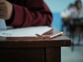 High school student examination Students are taking exams in stress in a classroom with broken pencils on the table Royalty Free Stock Photo