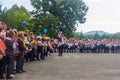 High school student with a first grader in her arms and other schoolchildren in the schoolyard at the grand opening of the school