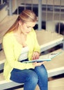 High school student girl reading book on stairs Royalty Free Stock Photo