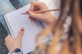 Close up photo of girl`s hands writing composition in her diary