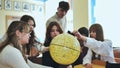 High school students looking at the yellow globe of the moon.