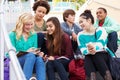 High School Students Sitting Outside Building With Phones Royalty Free Stock Photo