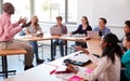 High School Teacher Talking To Pupils Using Digital Devices In Technology Class Royalty Free Stock Photo