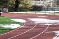 High school track with patches of snow and ice still on it Royalty Free Stock Photo