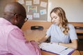 High School Tutor Giving Female Student One To One Tuition At Desk Royalty Free Stock Photo