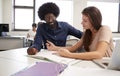 High School Tutor Giving Female Student One To One Tuition At Desk In Classroom Royalty Free Stock Photo