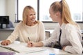 High School Tutor Giving Uniformed Female Student One To One Tuition At Desk In Classroom Royalty Free Stock Photo