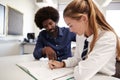 High School Tutor Giving Uniformed Female Student One To One Tuition At Desk In Classroom Royalty Free Stock Photo