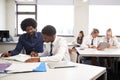 High School Tutor Giving Uniformed Male Student One To One Tuition At Desk In Classroom Royalty Free Stock Photo