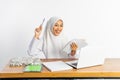 high school veiled girl at desk finds solution doing assignment
