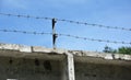 High security fencing: A close-up of a concrete security fence with barbed wire steel razor wire to protect the property from