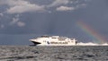 High-speed ferry crossing Kattegat to Aarhus under rainclouds and a rainbow, Denmark Royalty Free Stock Photo