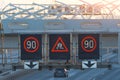 High-speed highway with traffic cars and electronic interactive speed limit signs and a slippery road warning Royalty Free Stock Photo