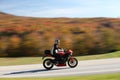 High speed motorcyclist on autumn background