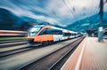 High speed orange train in motion on the railway station Royalty Free Stock Photo