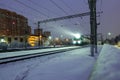 High-speed passenger electric train at night. A beam of train spotlight illuminates the falling snow Royalty Free Stock Photo