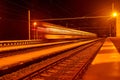 High speed passenger train on tracks with motion blur effect at night. Railway station in the Czech Republic Royalty Free Stock Photo