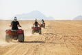 High speed race of several people riding quad bikes in desert