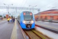 High speed suburban train passes by the passenger station at fast velocity with the effect of movement Royalty Free Stock Photo