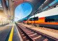 High speed train on the modern railway station at sunset