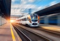 High speed train in motion at the railway station at sunset