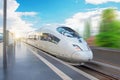 High speed train passes by the passenger station at fast velocity with the effect of movement Royalty Free Stock Photo