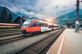 High speed train on the railway station in mountains at sunset Royalty Free Stock Photo