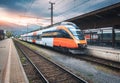 High speed train on the railway station in mountains at sunset Royalty Free Stock Photo
