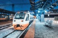 High speed train on the railway station at night in winter Royalty Free Stock Photo