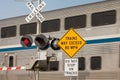 High speed train warning sign at railroad crossing with motion blur of train in background. Royalty Free Stock Photo