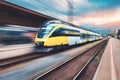 High speed yellow train in motion on the railway station Royalty Free Stock Photo