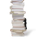 High stack of books with businessman climbing it Royalty Free Stock Photo