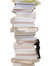 High stack of books with businessman climbing it Royalty Free Stock Photo