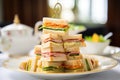 a high stack of cut clubhouse sandwiches for high-tea