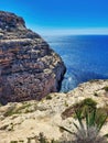 High stony coast at deep blue sea. Beach, ocean. Wild beach. Mountain, house, view, tourism, tree. The mountain is over the sea Royalty Free Stock Photo