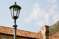 High street lamp at the level of the roof of the house against the background of mountains and sky. Royalty Free Stock Photo