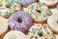High sugar food. Close up shot of assorted round glazed donuts with colorful sprinkles Royalty Free Stock Photo